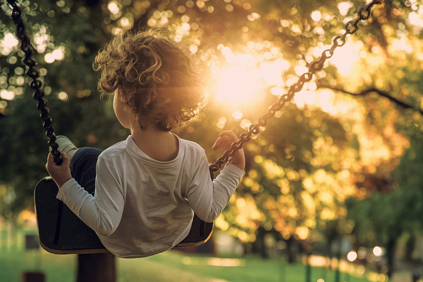 Child on Swing, Sunshine coming through the trees